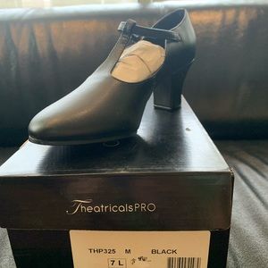 Black T-strap character shows. 2 inch heel. New. Size 7.